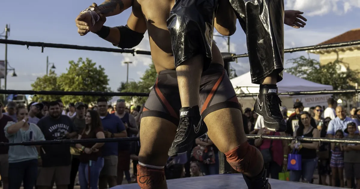 Luchador in red and gold mask emerging from darkness